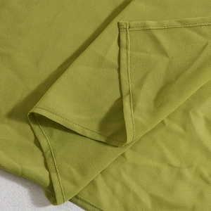 Detailaufnahme von olivgrünem Chiffon-Stoff mit präzisen Saumnähten und feiner Textur