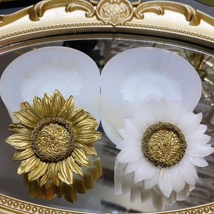Macro detail of sunflower silicone molds with finished resin flowers on mirror