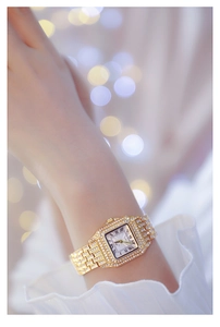 Detail of luxury gold square quartz watch with crystal inlay and Roman numerals
