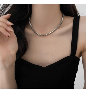 Close-up of elegant grey pearl necklace with silver beads on a model's neck