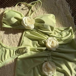 Detailed view of lime green bikini set featuring 3D white camellia flower accents