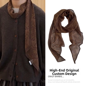 Close-up of deep brown paisley silk scarf necklace with elegant textile pattern detail