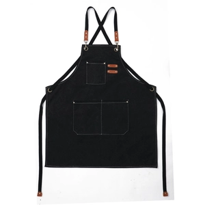 Waterproof black canvas apron with brown leather straps and pockets on white background