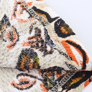 Detailaufnahme von Plissee-Stoff mit orange-schwarzem Tierprint und feiner Kantenverarbeitung