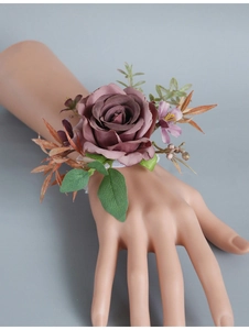 Detail of vintage pink rose wrist corsage with purple flowers and white lace elastic band
