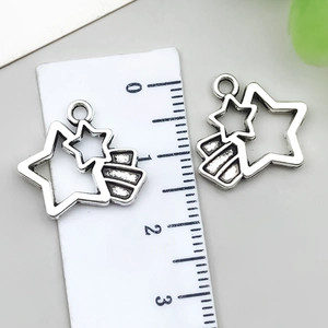 Detail of silver star pendants with ruler showing approximate 2cm length and fine craftsmanship