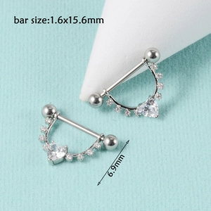 Macro view of silver heart nipple shields with clear zircon inlays and bar size details