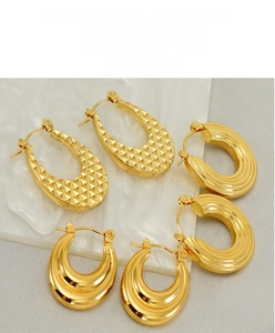 Three pairs of chunky 18K gold plated stainless steel hoops on marble background