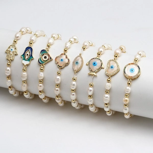 Set of eight baroque freshwater pearl bracelets with golden evil eye and heart charms