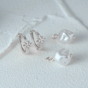 Detailed macro of S925 silver star hoop earring with baroque pearl and micro-pave zircons