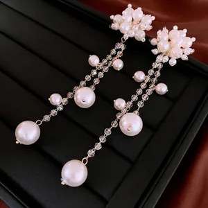 Boucles d'oreilles fleurs en perles avec glands en cristal sur boîte à bijoux velours noir