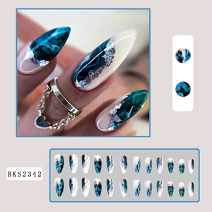 Long stiletto press-on nails with dark teal marble ink patterns and silver foil accents