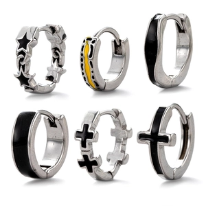 Detailed macro view of six silver stainless steel hoop earrings with cross and star motifs