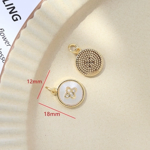 Macro shot of 12mm gold-plated shell pendant with diamond cross on ceramic plate