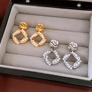 Detail shot of 18K gold plated and silver earrings with pearls in a jewelry display box