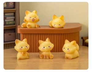 Close-up of cute resin fox figurines with various poses on a wooden miniature scene