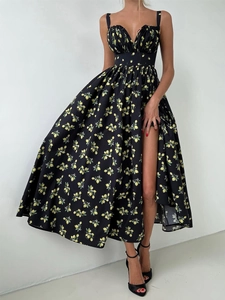Detail of high waist slit and vibrant lemon floral print on long black summer dress