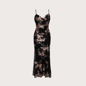 Détail d'une robe noire avec broderie florale en paillettes dorées et fente