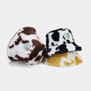 Cute plush cow print bucket hats in black, brown, and yellow with soft faux fur texture