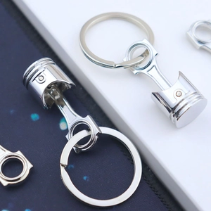 Detailed view of silver metal piston and connecting rod shaped automotive keychains