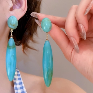 Detail view of teal marble drop earrings with gold connector for a minimalist style