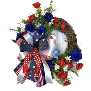 Patriotic July 4th wreath with red blue flowers and stars stripes ribbon on vine base