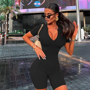 Close-up of black tight bodysuit featuring a short sleeve deep V-neck design on city street