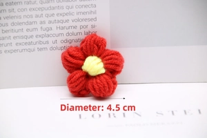 Detailed view of a 4.5cm handcrafted crochet red flower with yellow center accent