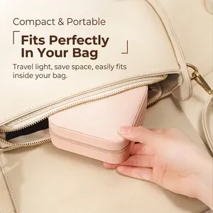 Mini light pink PU leather jewelry box being placed into a bag for easy travel storage