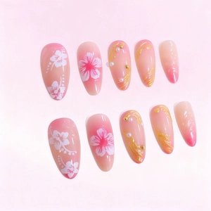 Pink ombre almond press-on nails with white flowers, gold foil, and pearl accents