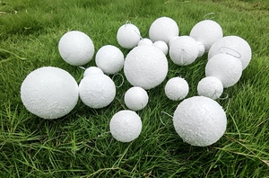 Macro detail of textured white foam Christmas balls with wire hooks for holiday hanging