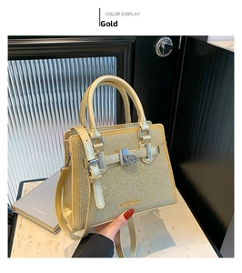 Detail of gold sequin handbag with rhinestone finish, metal buckle, and padlock accent