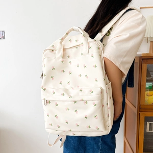 Detail of floral canvas backpack featuring pink rose patterns on a cream base fabric
