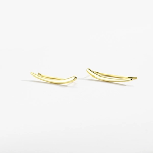 Close-up of minimalist gold curved ear climber earrings with smooth metallic finish