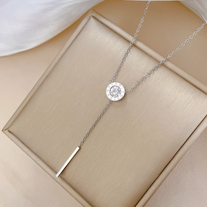 Detailed close-up of a silver roman numeral pendant with tassel on a luxury stand
