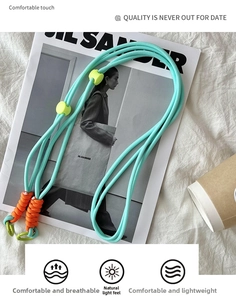Close-up of woven light blue crossbody strap with neon yellow slider and green hook