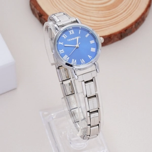 Close-up of a silver stainless steel watch with a blue Roman numeral dial on a stand