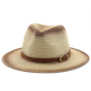 Macro view of woven straw sun hat texture with brown faux leather belt and gold buckle