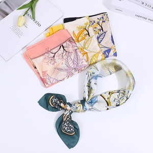 Detailed view of floral cashew print silk scarves with decorative books and tulips