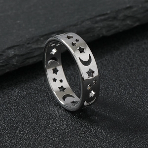 Silver stainless steel band ring featuring hollow moon and stars pattern on dark stone