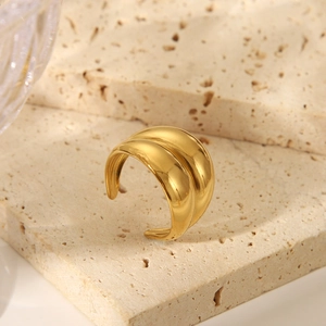 Detailed view of a gold double-layered striped open ring on a travertine stone pedestal
