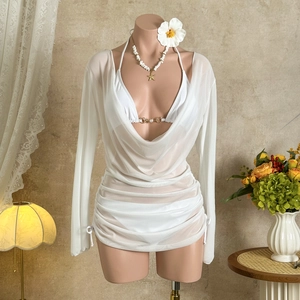 Close-up of white mesh beach cover-up with gold buckle bikini on a mannequin