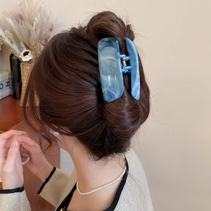 Detailansicht der großen Haarspange mit blauem Marmormuster für elegantes Haarstyling