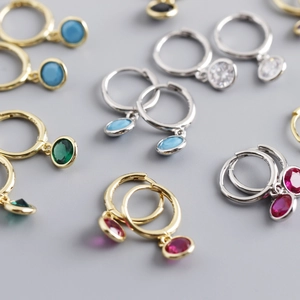 Macro shot of S925 silver hoop earrings with vibrant multi-colored zircon pendants