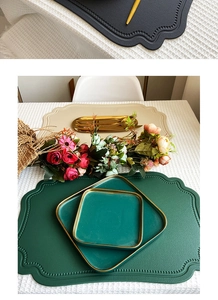 Macro detail of dark green and beige faux leather placemats with scalloped edges