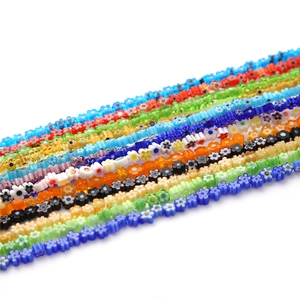 Colorful flower-shaped glass beads for DIY jewelry making neatly arranged on white background