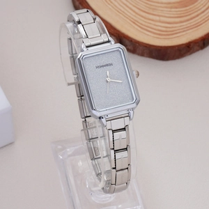 Detailed view of rectangle silver watch with glitter grey dial on a minimalist stand