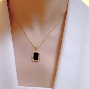 Elegant gold necklace with a black rectangular pendant and sparkling crystals