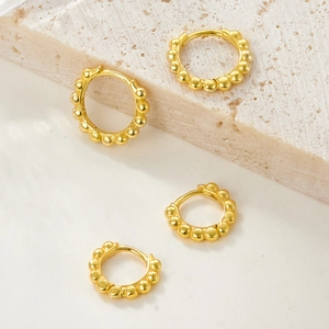 Macro shot of 925 sterling silver gold beaded earrings showing S925 hallmark stamps