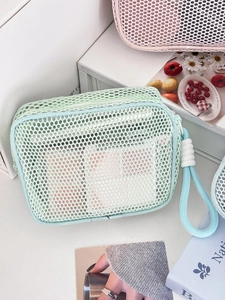 Detail of mint green mesh toiletry bag with white thick cotton rope handle and zipper